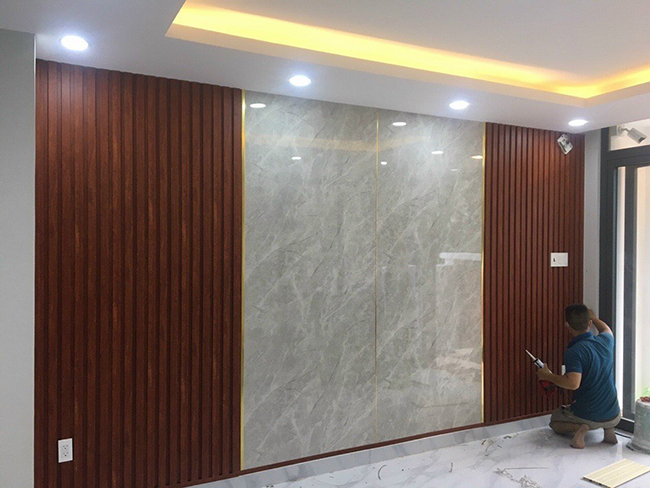 Xu hướng ốp tường phòng khách tấm ốp PVC vân đá kết hợp lam sóng hiện đại